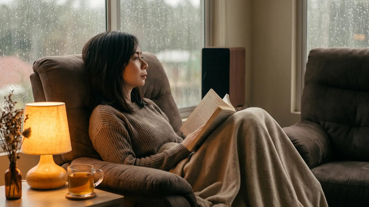 Woman lost in a book by a rainy window, the quiet pull of INFP escapism